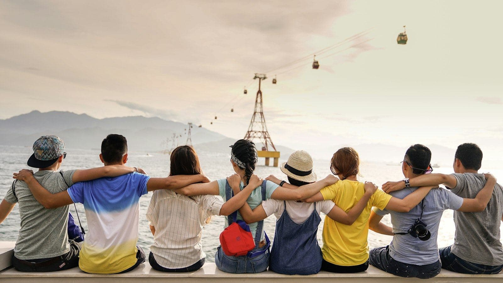 Friends sitting shoulder to shoulder looking toward the horizon